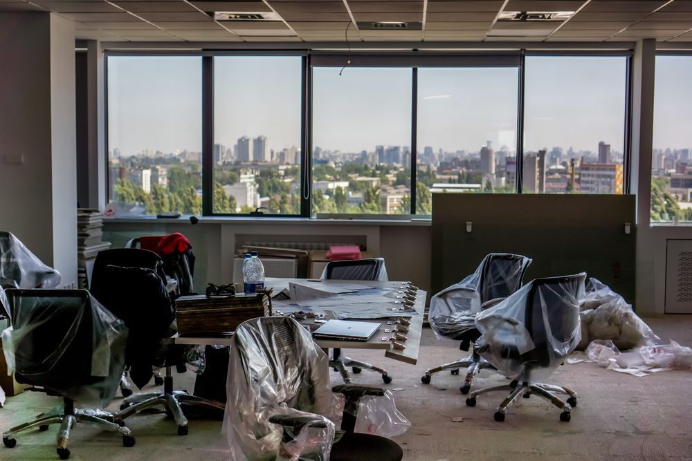 Empty Office Space With Large Windows Overlooking a City Skyline — Uplift Removals in Logan, QLD