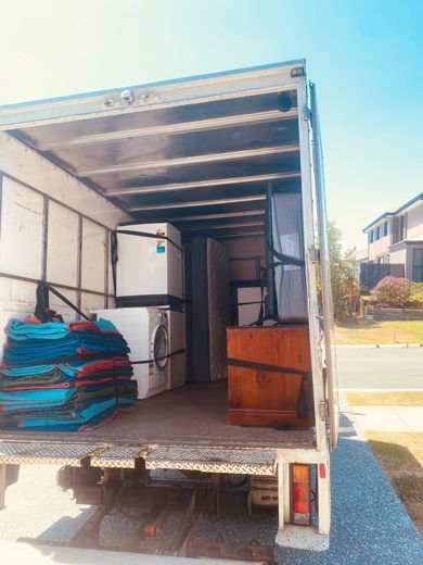 A Moving Truck Filled With Furniture And Appliances Is Parked On The Side Of The Road — Uplift Removals in Burdell, QLD