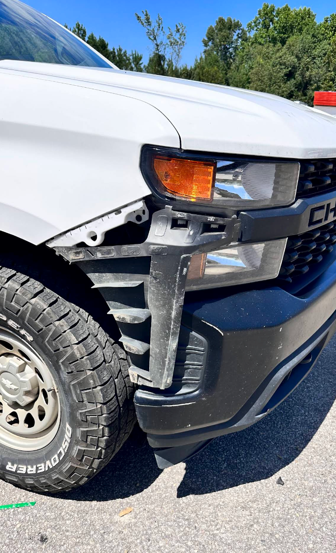 Damaged white vehicle front-left corner with torn bumper and exposed wheel well. | Momax Wheels and Auto LLC