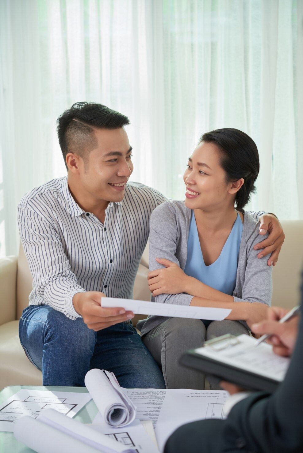 Two people smiling and talking over papers in a bright office setting