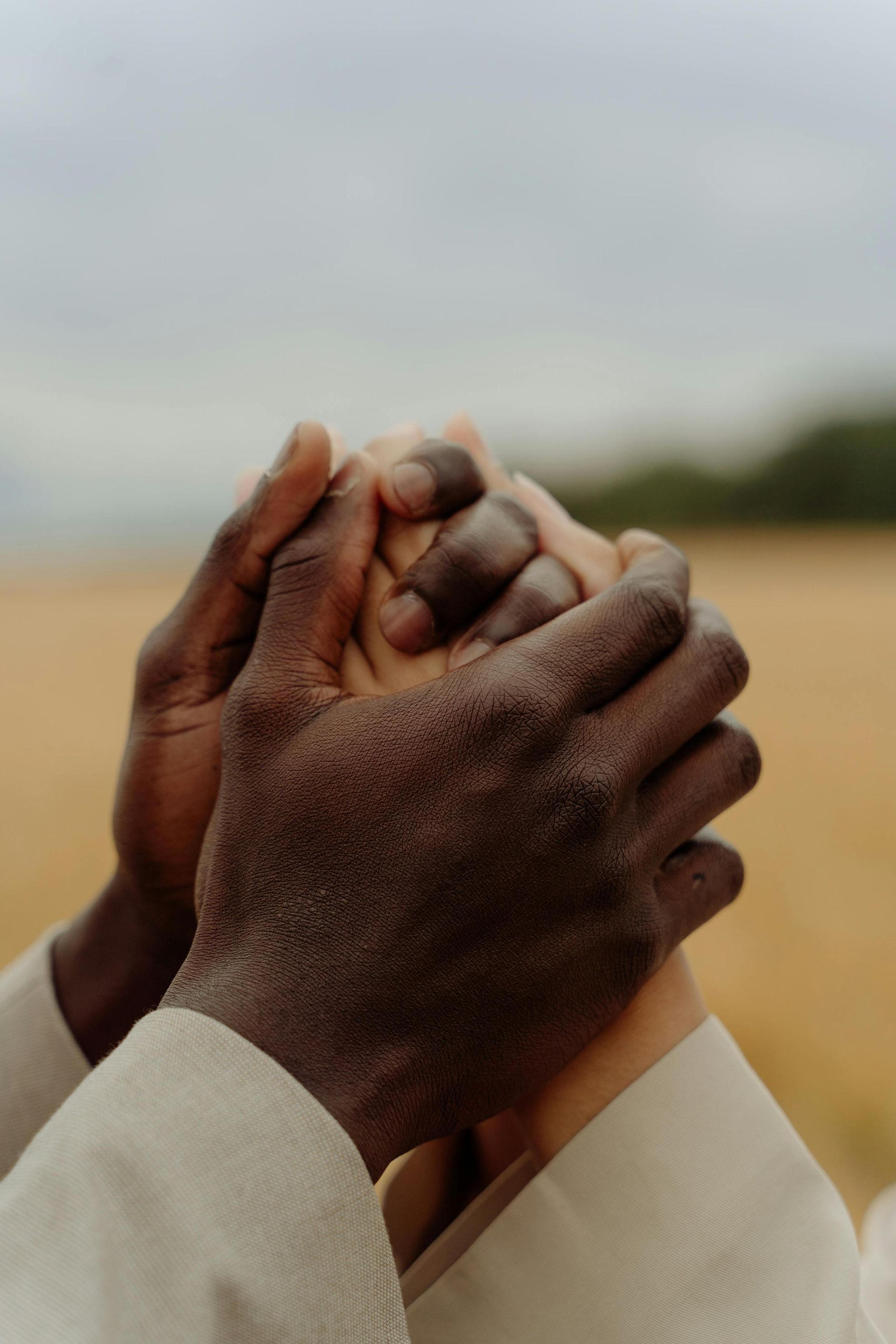 A man and a woman are holding hands in a field.