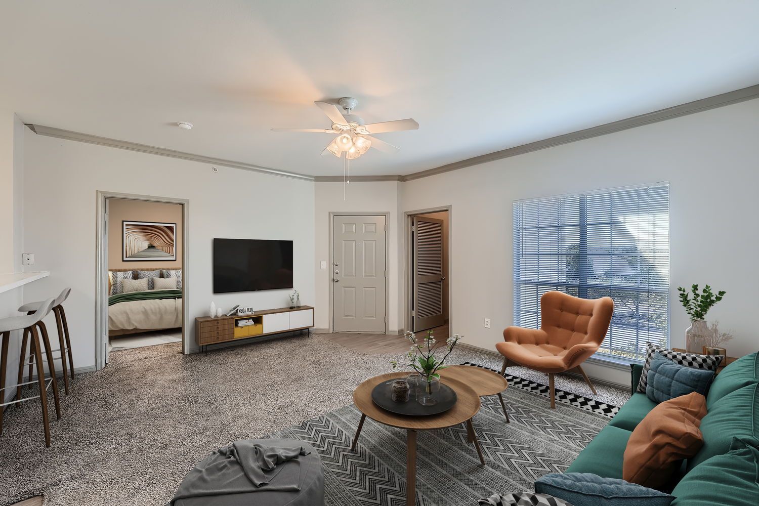 A living room with a couch , chair , coffee table and television.