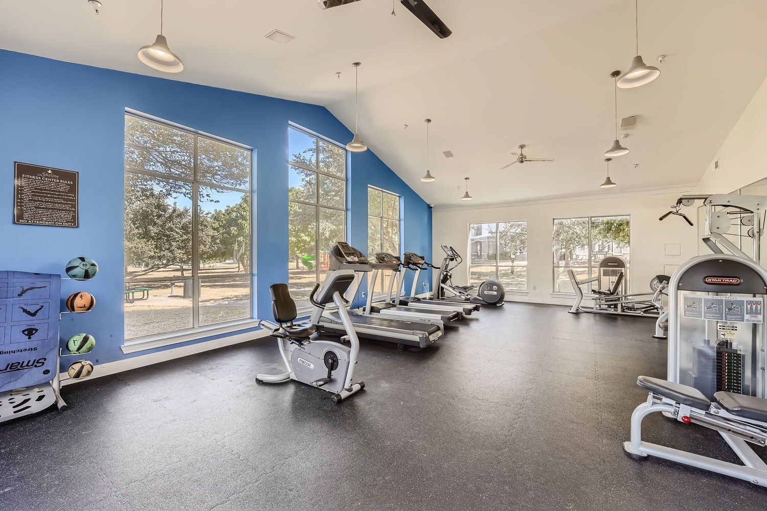 A large gym with treadmills , bikes , and other exercise equipment.