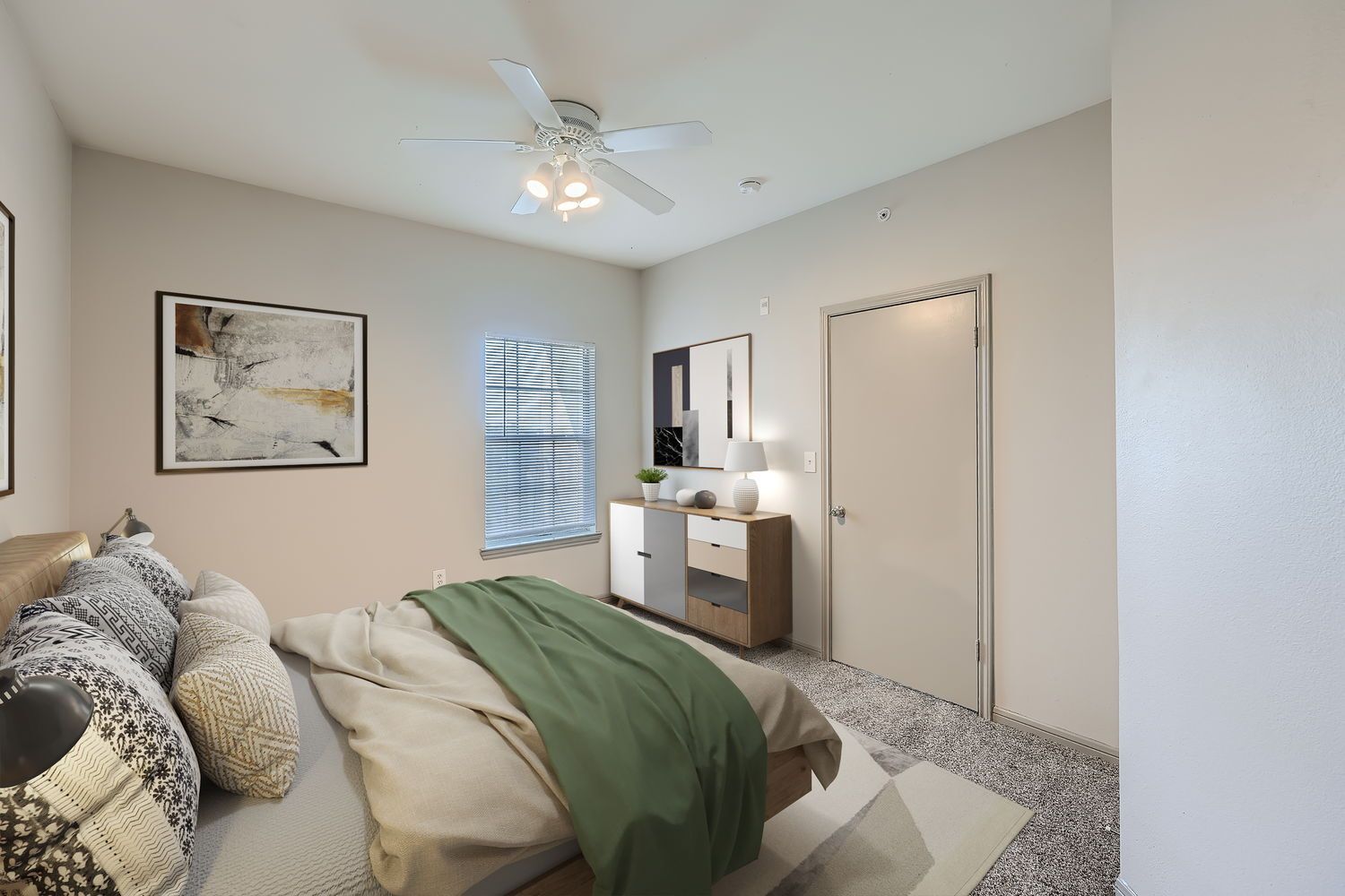 A bedroom with a bed , dresser , mirror and ceiling fan.