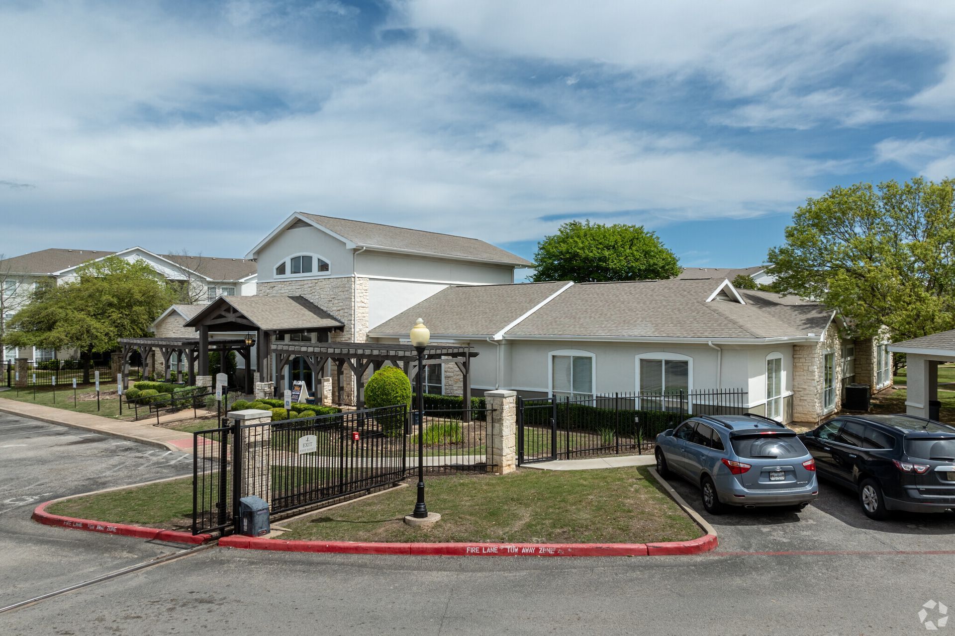 A large white house with cars parked in front of it.