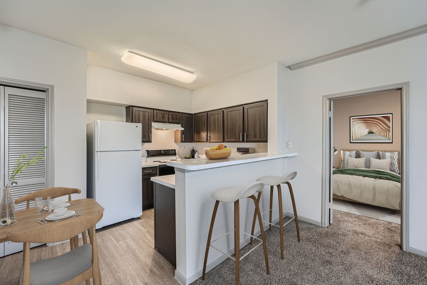 A kitchen with a table and chairs and a refrigerator.