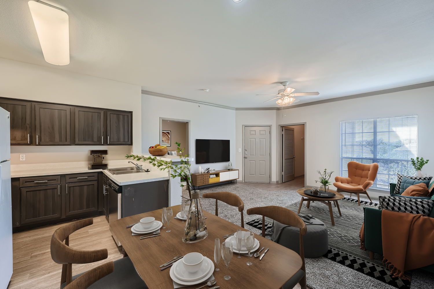 A living room with a dining table and chairs and a kitchen.