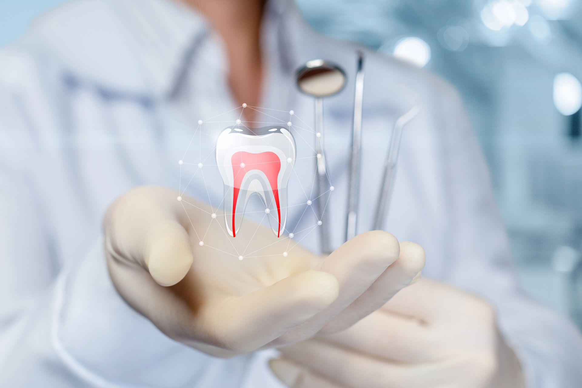Dentista che tiene in mano un'illustrazione digitale di un dente; sullo sfondo ci sono degli strumenti odontoiatrici.
