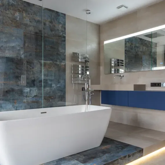 A bathroom with a bathtub , sink and mirror.