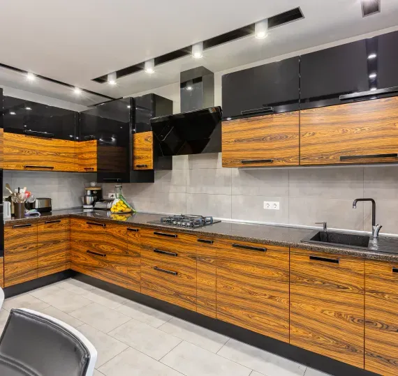 A kitchen with wooden cabinets and black counter tops