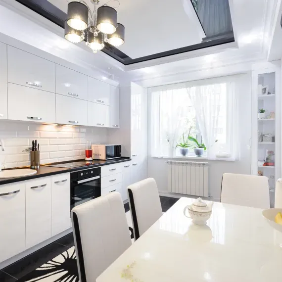 A kitchen with white cabinets and a table and chairs