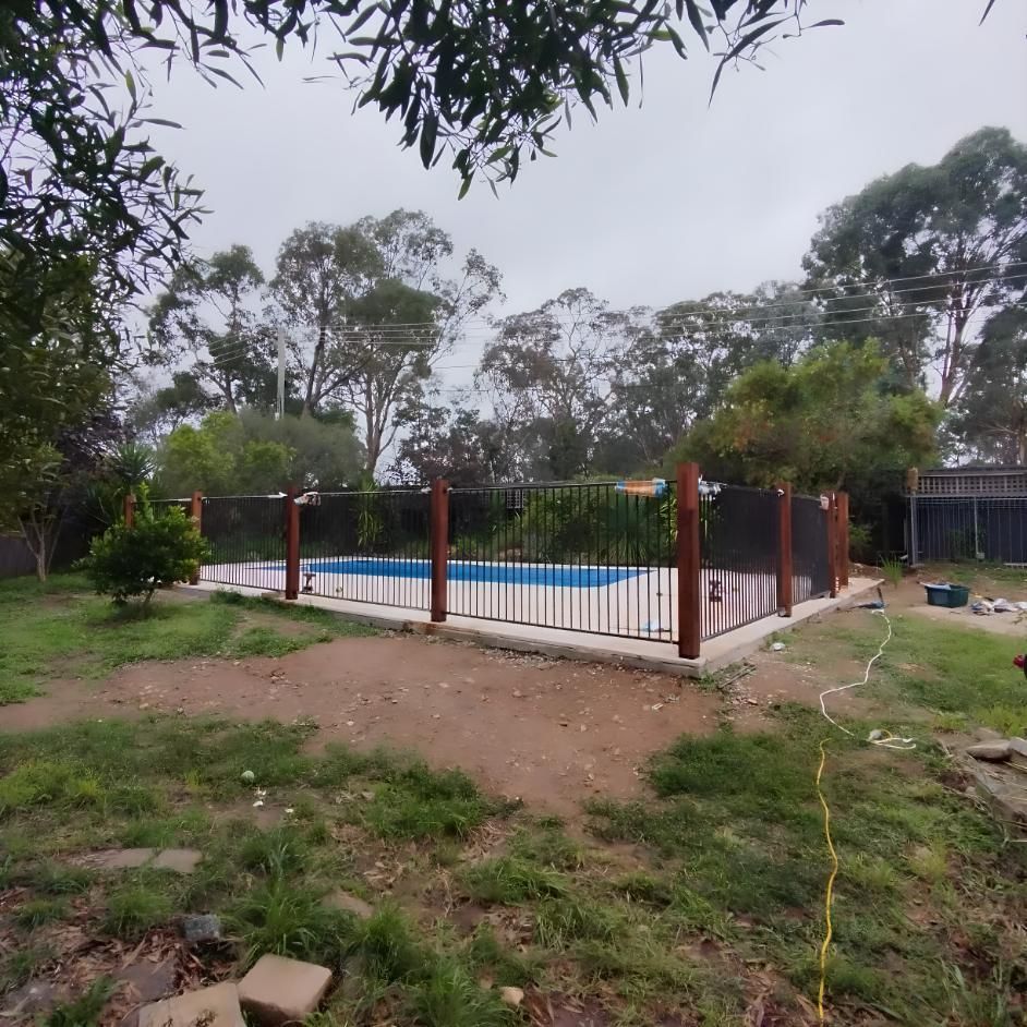 A Fence Around A Swimming Pool With Trees In The Background — Landschape In Braddon, ACT