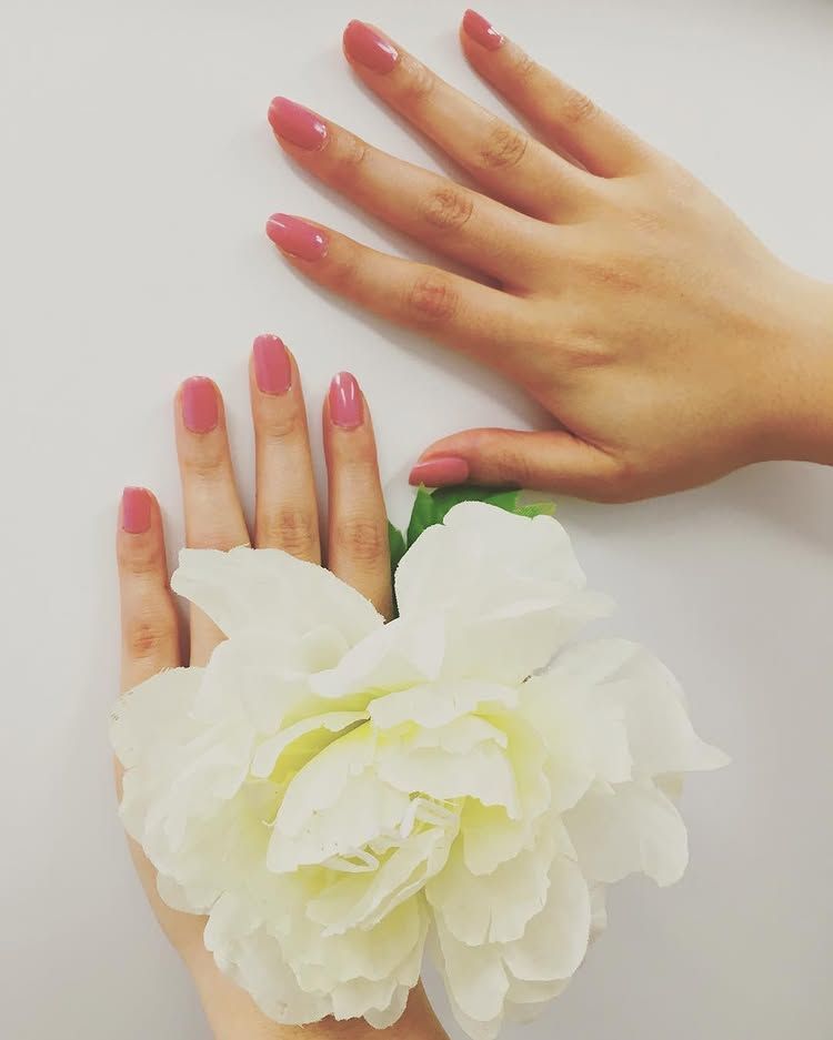 Person getting their nails painted at a salon.