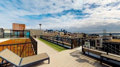 Modern H2O Apartments living room in Seattle with natural light, hardwood floors, stylish sofa, and home workspace