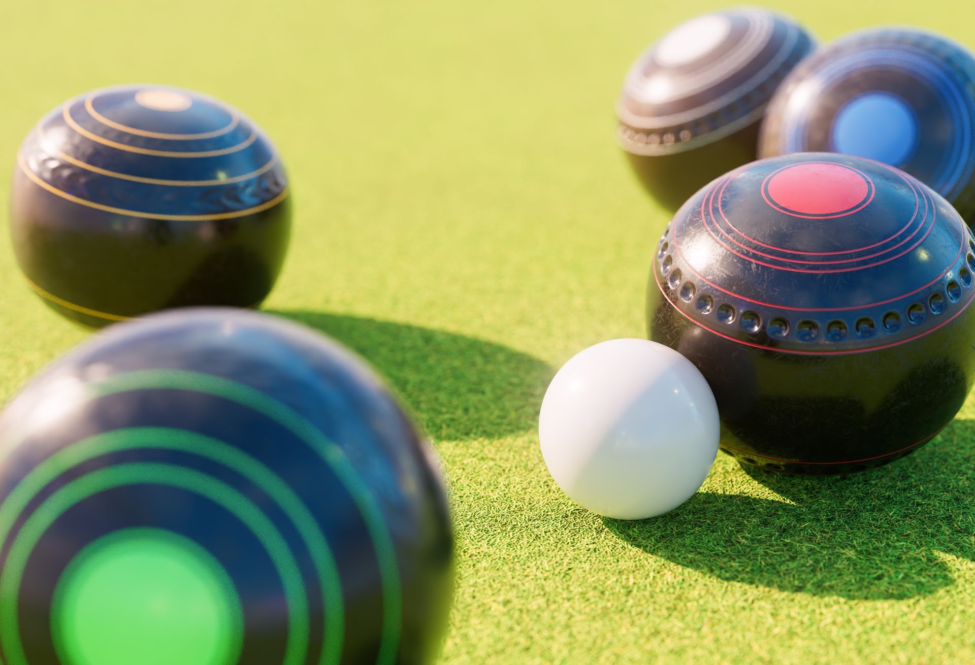 a group of lawn bowling balls sitting on top of a green field .