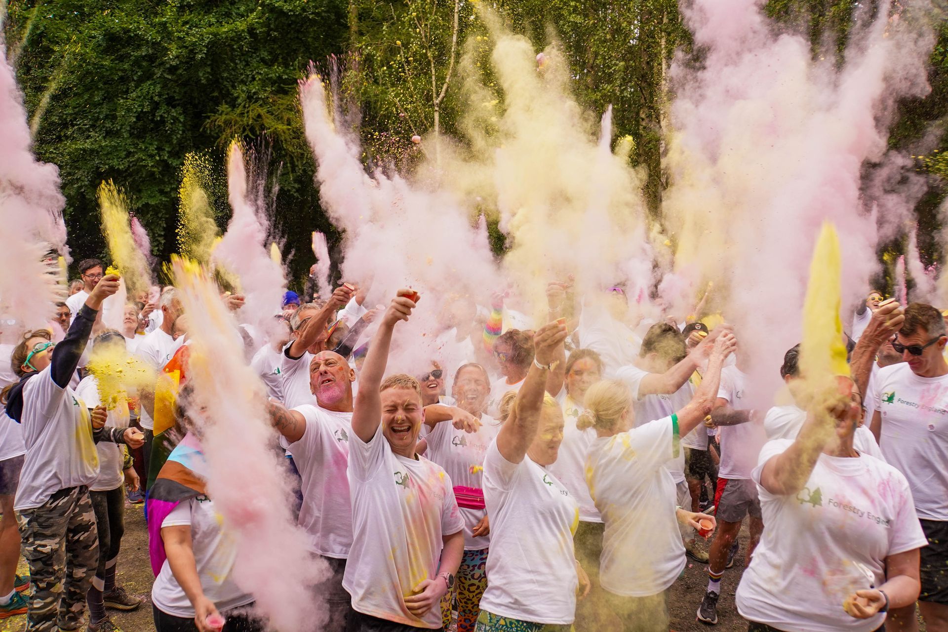 A group of people are throwing colored powder in the air.