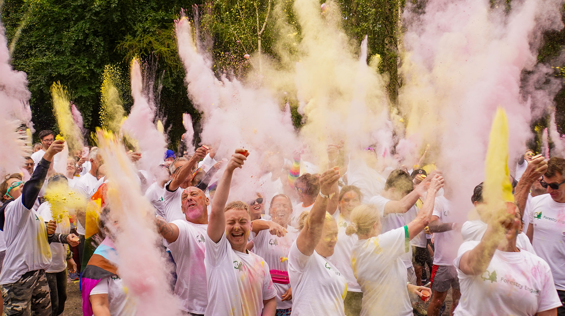 A group of people are throwing colored powder in the air.