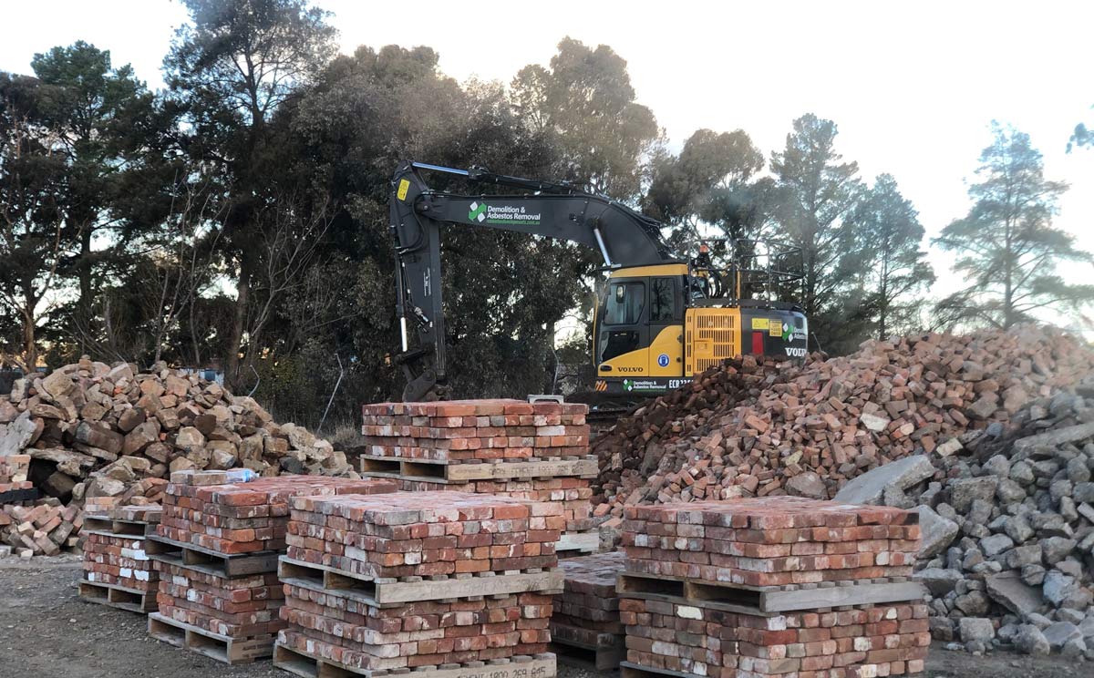 excavator on piles of brick