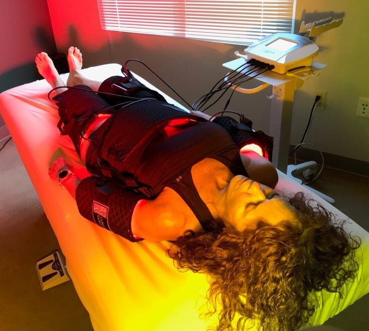 A woman is laying on a bed getting a RF Full Body Light Countering