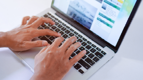 A person is typing on a laptop computer.