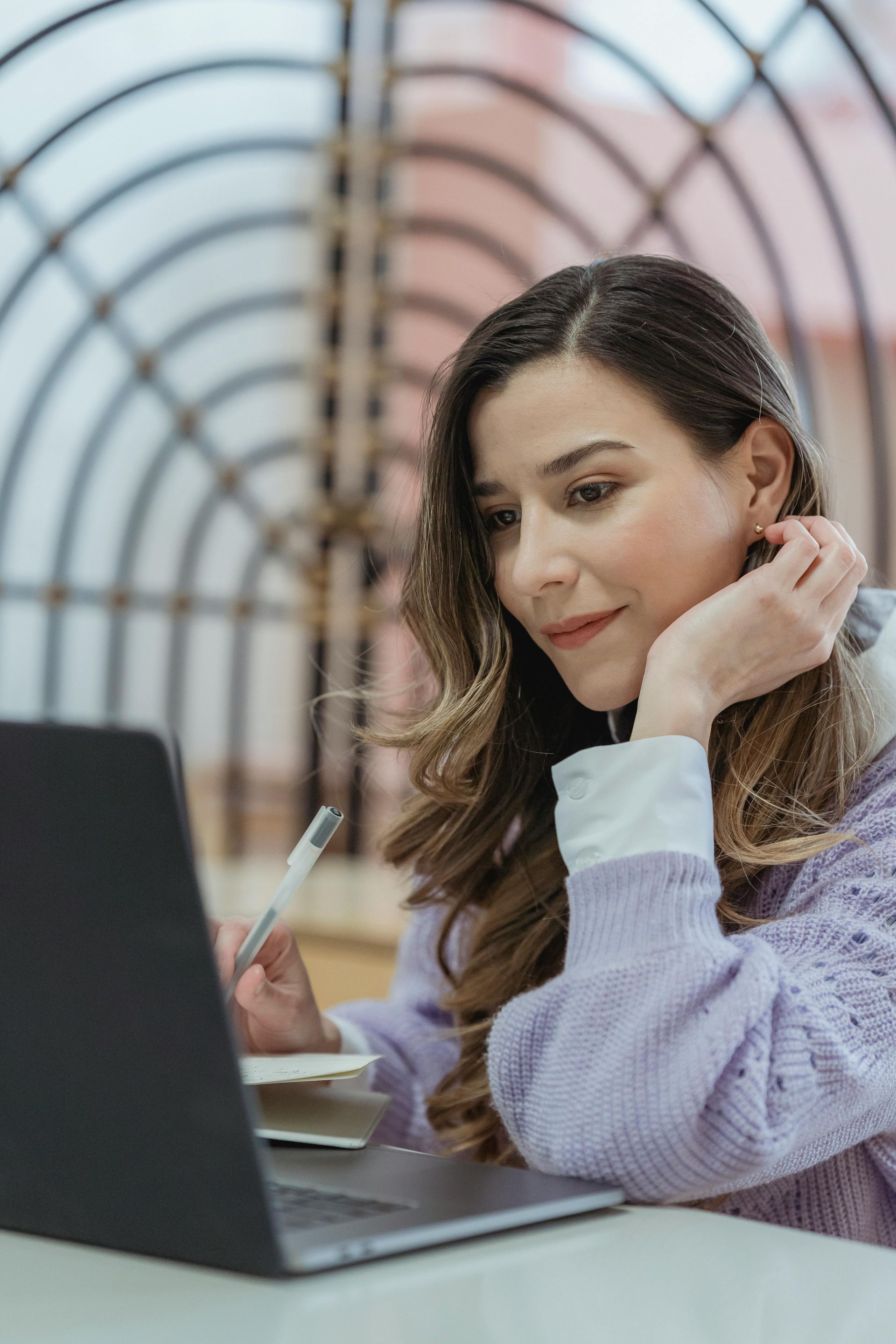 A woman is sitting at a table using a laptop computer.
