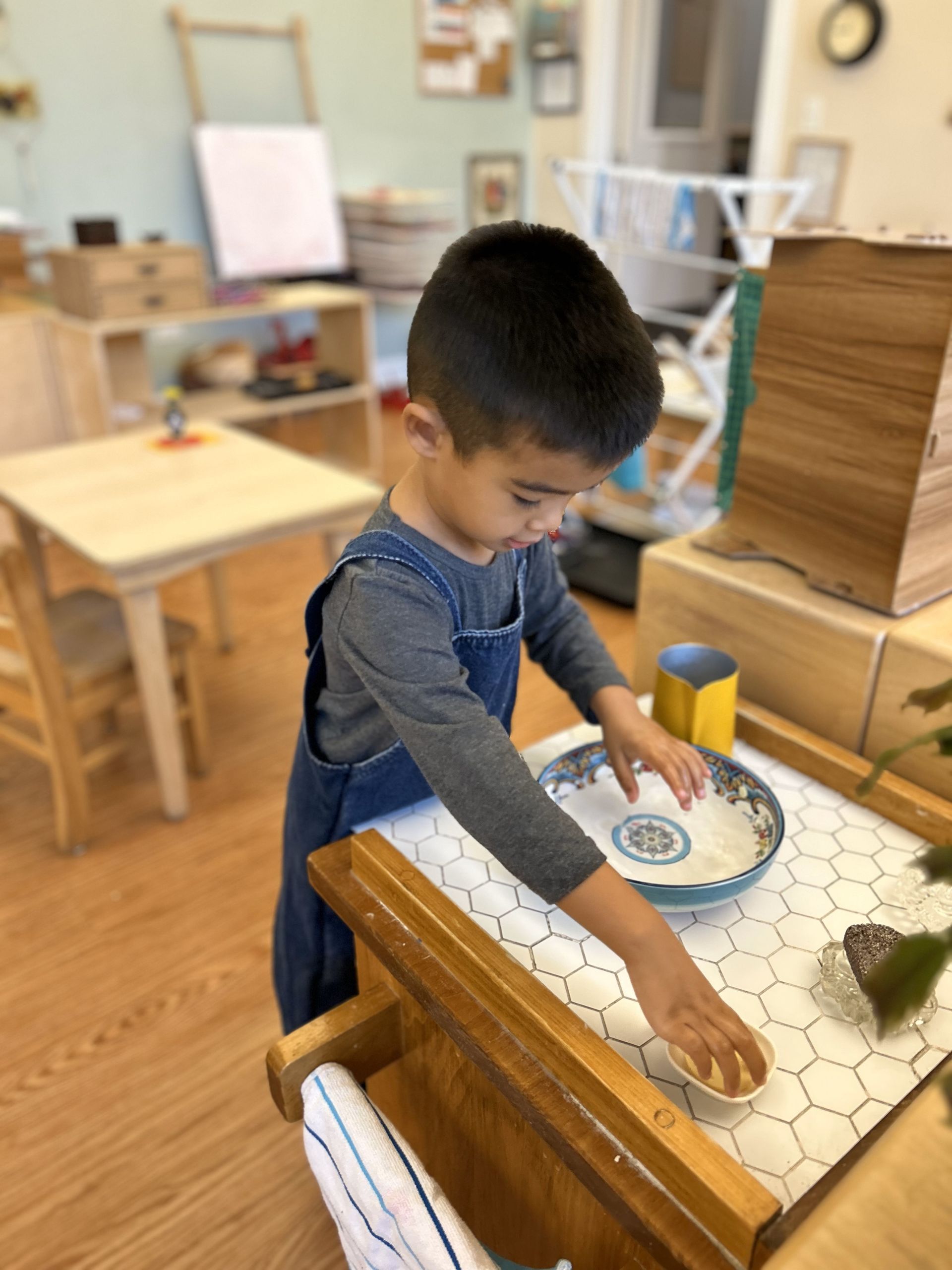 A wooden table with two stainless steel sinks and a picture of hands on it.