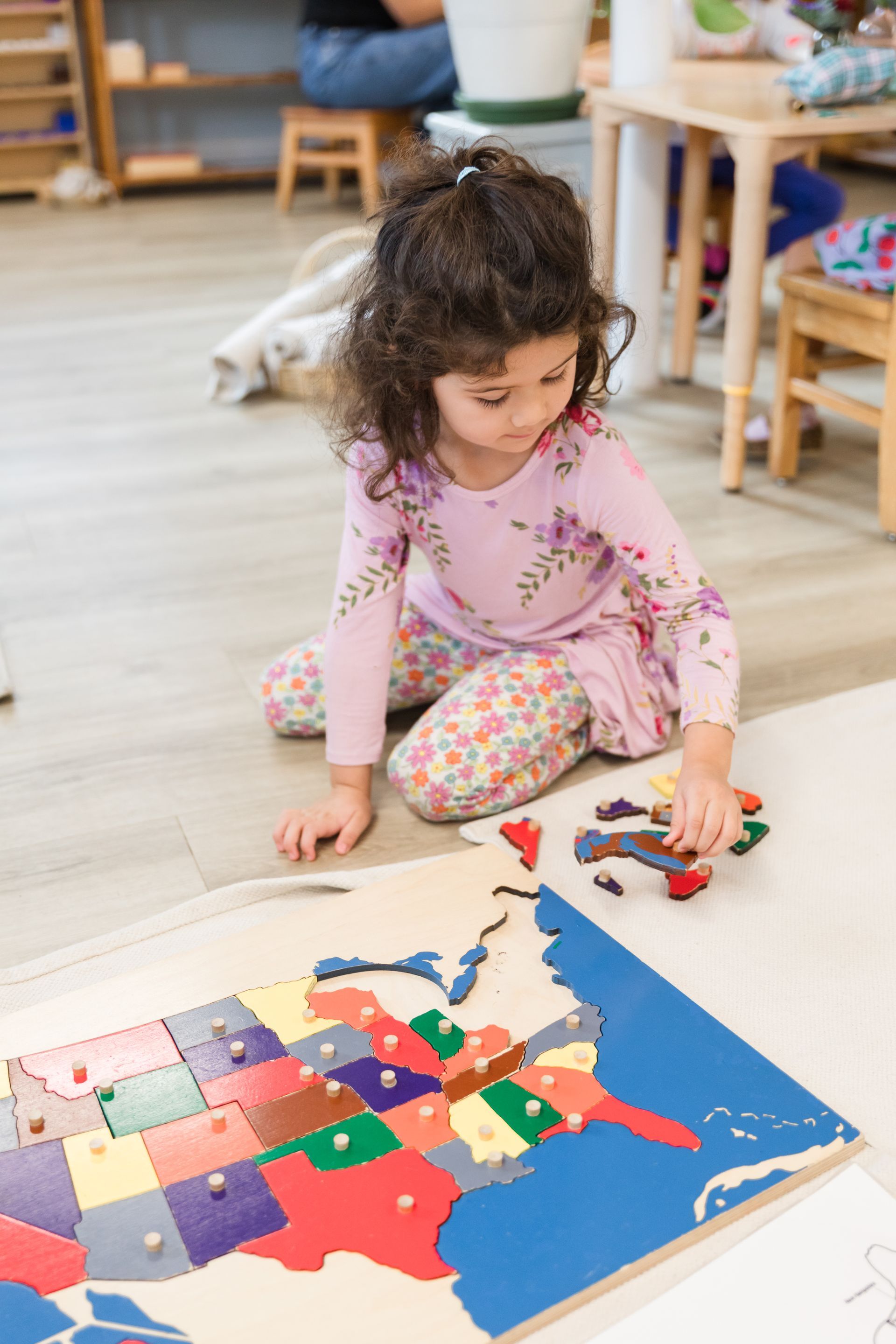 montessori child working with world puzzle