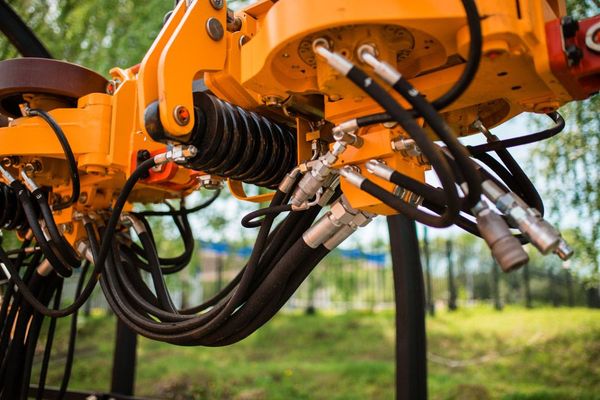 A Close up Of a Yellow Machine with Hydraulic Hoses Attached to It — Alice Hosetech & Industrial Supplies in Ciccone, NT