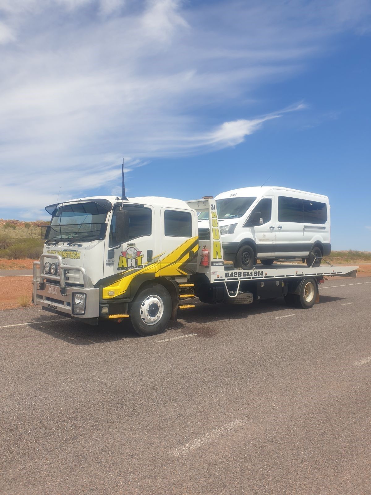 A Truck Is Carrying Two Vans on A Trailer on A Highway — Alice Hosetech & Industrial Supplies in Ciccone, NT