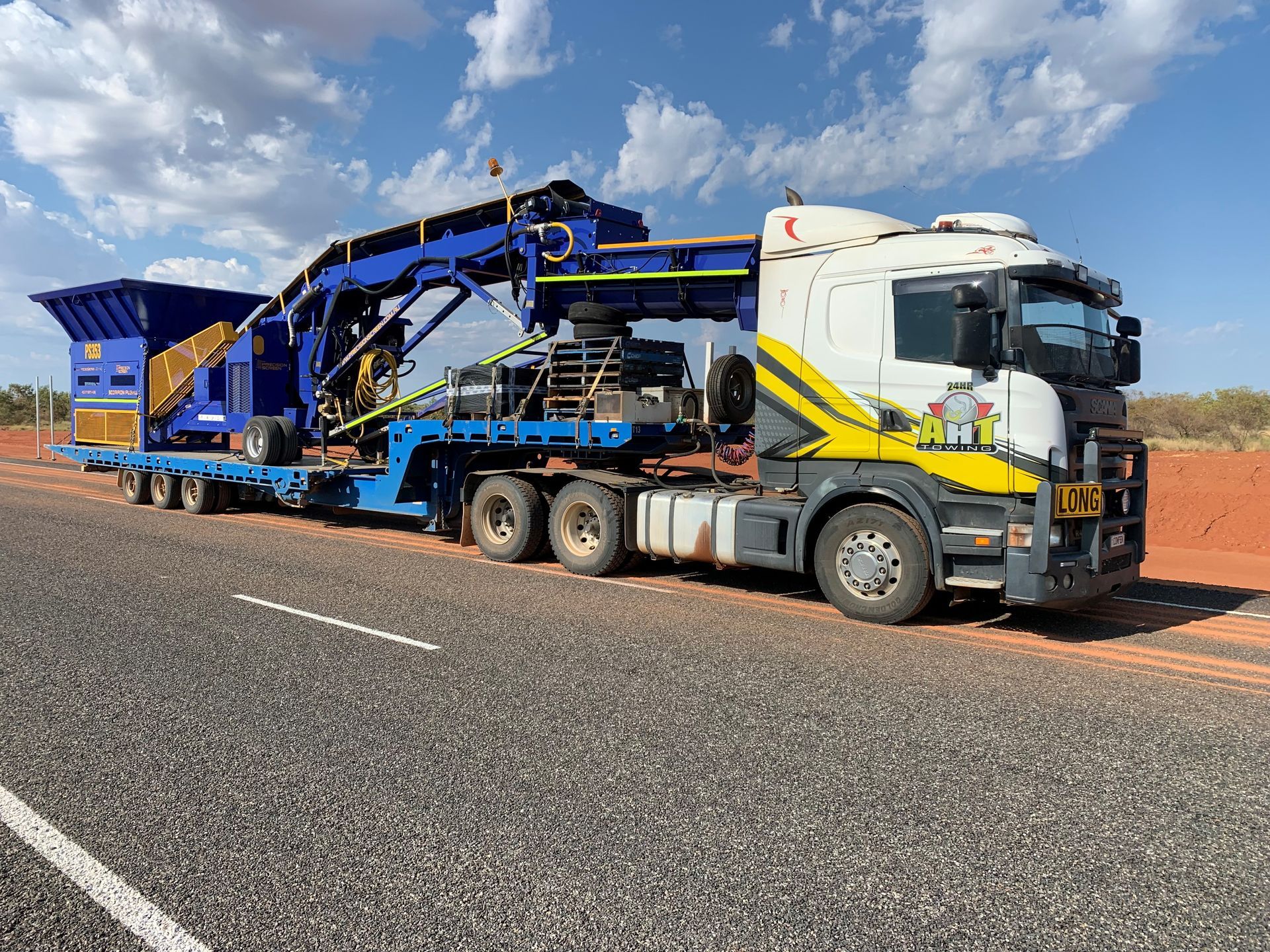 A Truck Is Carrying a Bulldozer on A Trailer on A Highway — Alice Hosetech & Industrial Supplies in Ciccone, NT