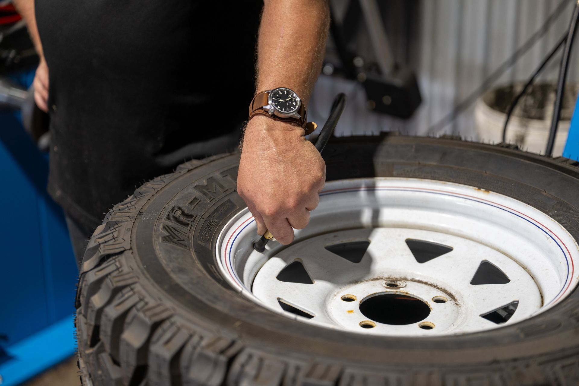 A Man Is Changing a Tyre on A Machine  — Cherry's Automotive Repairs In Maitland, NSW