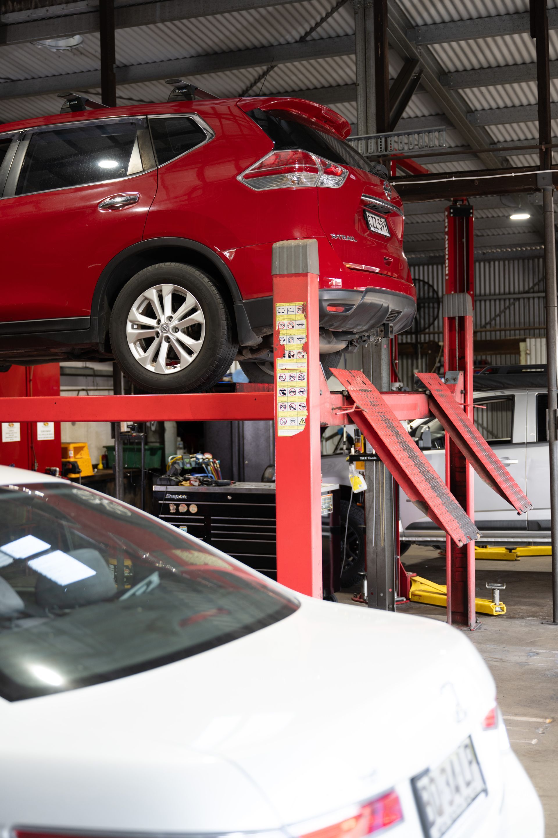 Mechanic Inspects Car Wheel, Taking Notes on Clipboard — Cherry's Automotive Repairs In Maitland, NSW