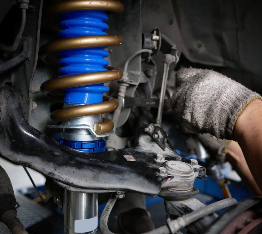 Mechanic Replacing A New Car Shock Absorbers — Cherry's Automotive Repairs In Maitland, NSW