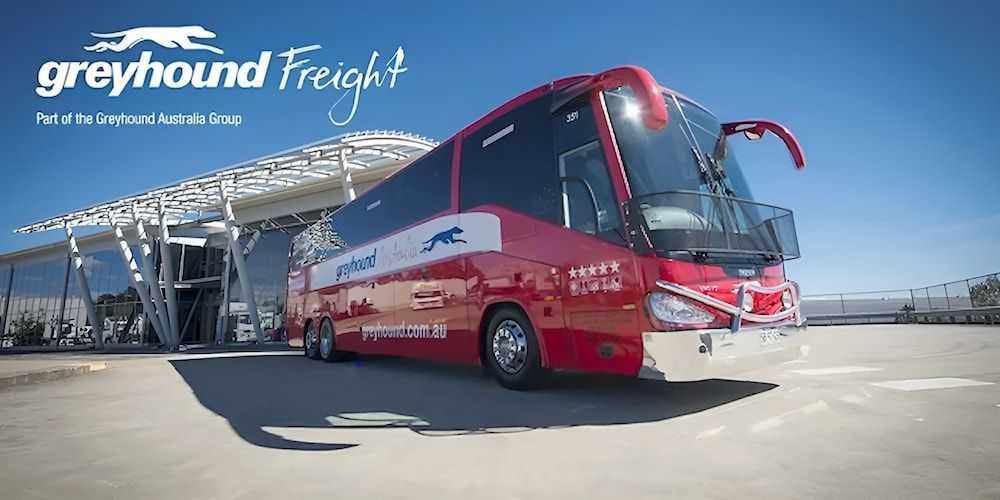 A Red And White Bus Is Parked In Front Of A Building — CC Couriers FNQ in Portsmith, QLD