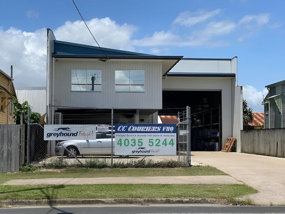 A White Car Is Parked In Front Of A Building That Says Cc Compound — CC Couriers FNQ in Portsmith, QLD