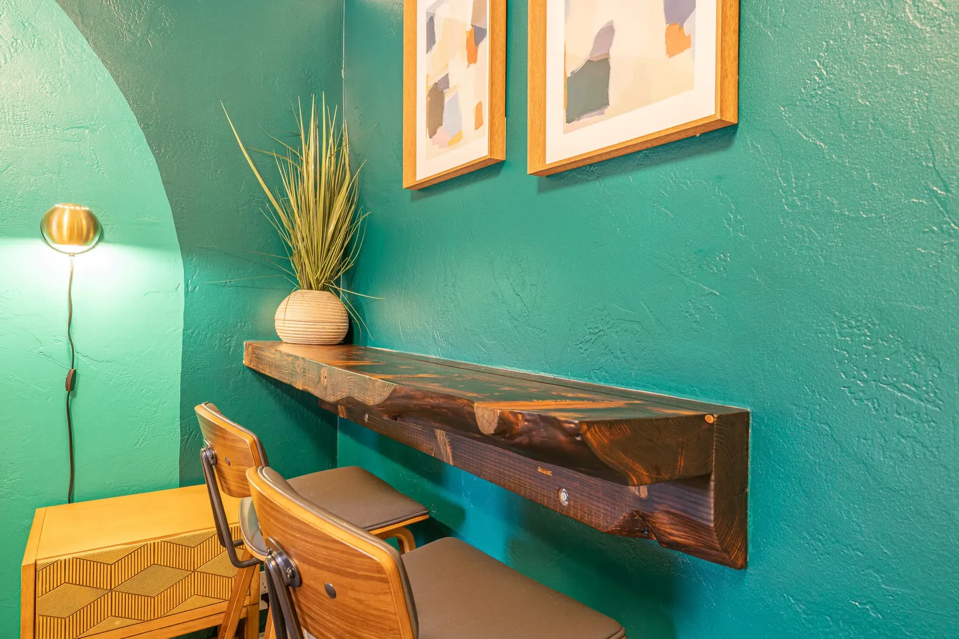 There is a shelf with a plant on it in the corner of the room.