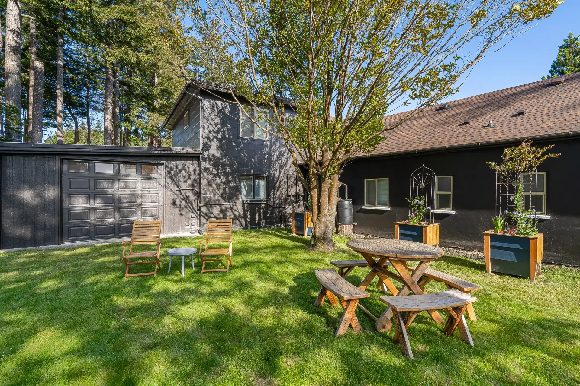 There is a picnic table in the grass in front of a house.