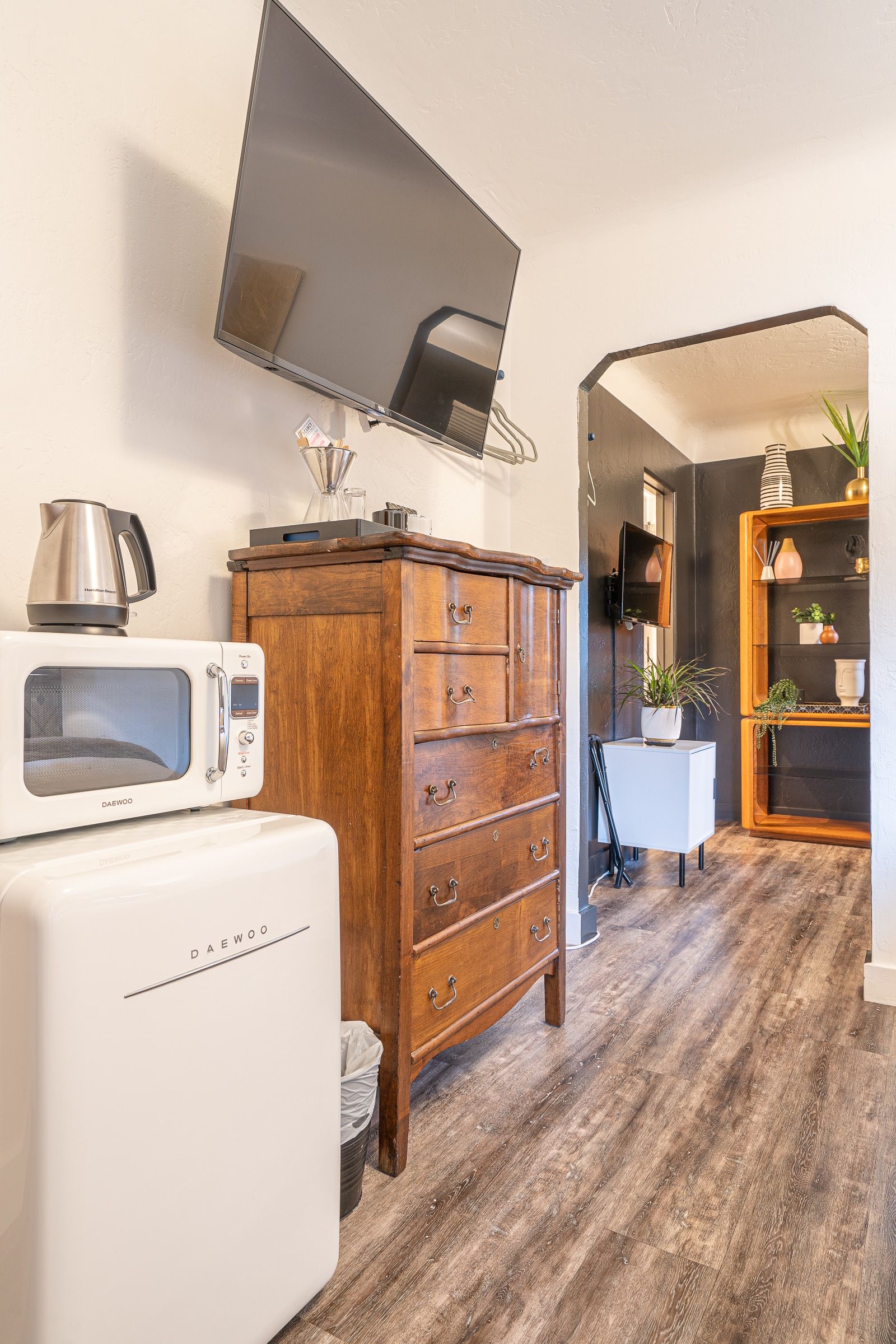 A living room with a dresser , microwave , and television.