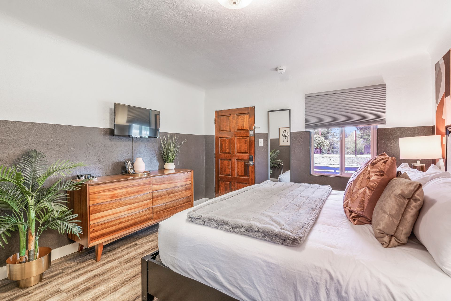 A bedroom with a king size bed , dresser , and television.