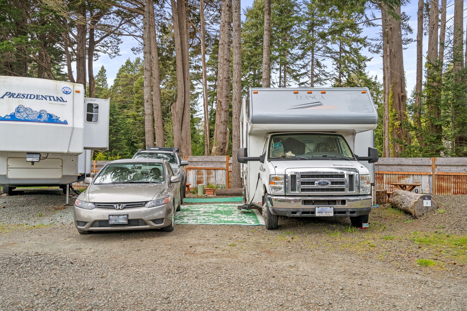 A rv and a car are parked next to each other in a parking lot.