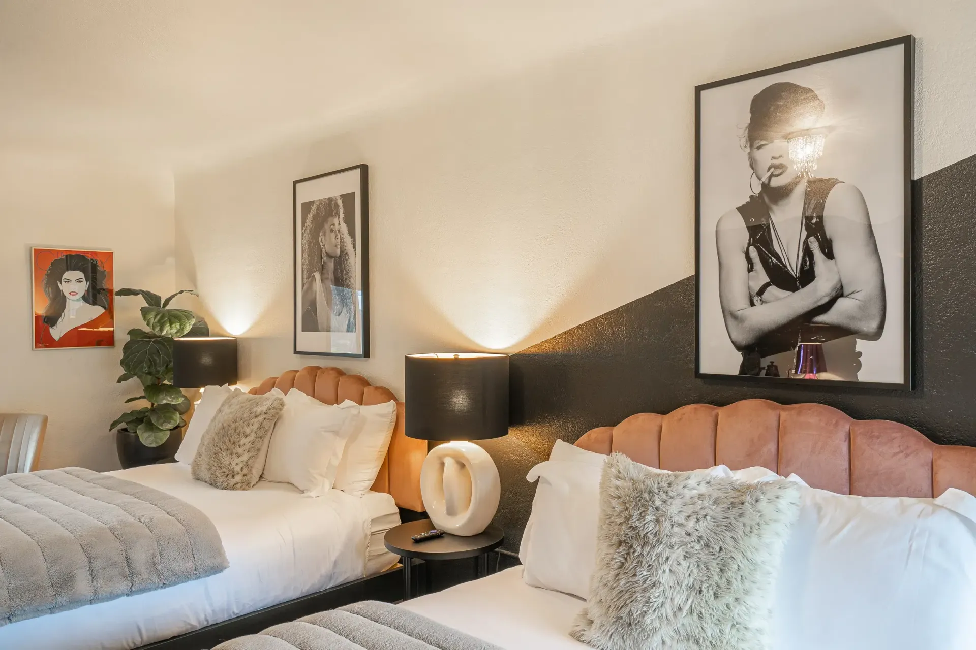 A hotel room with two beds and two pictures on the wall.
