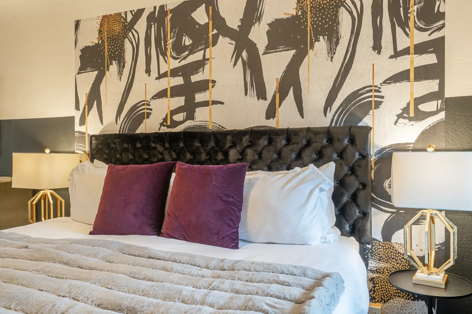 There is a large painting on the wall above the bed.