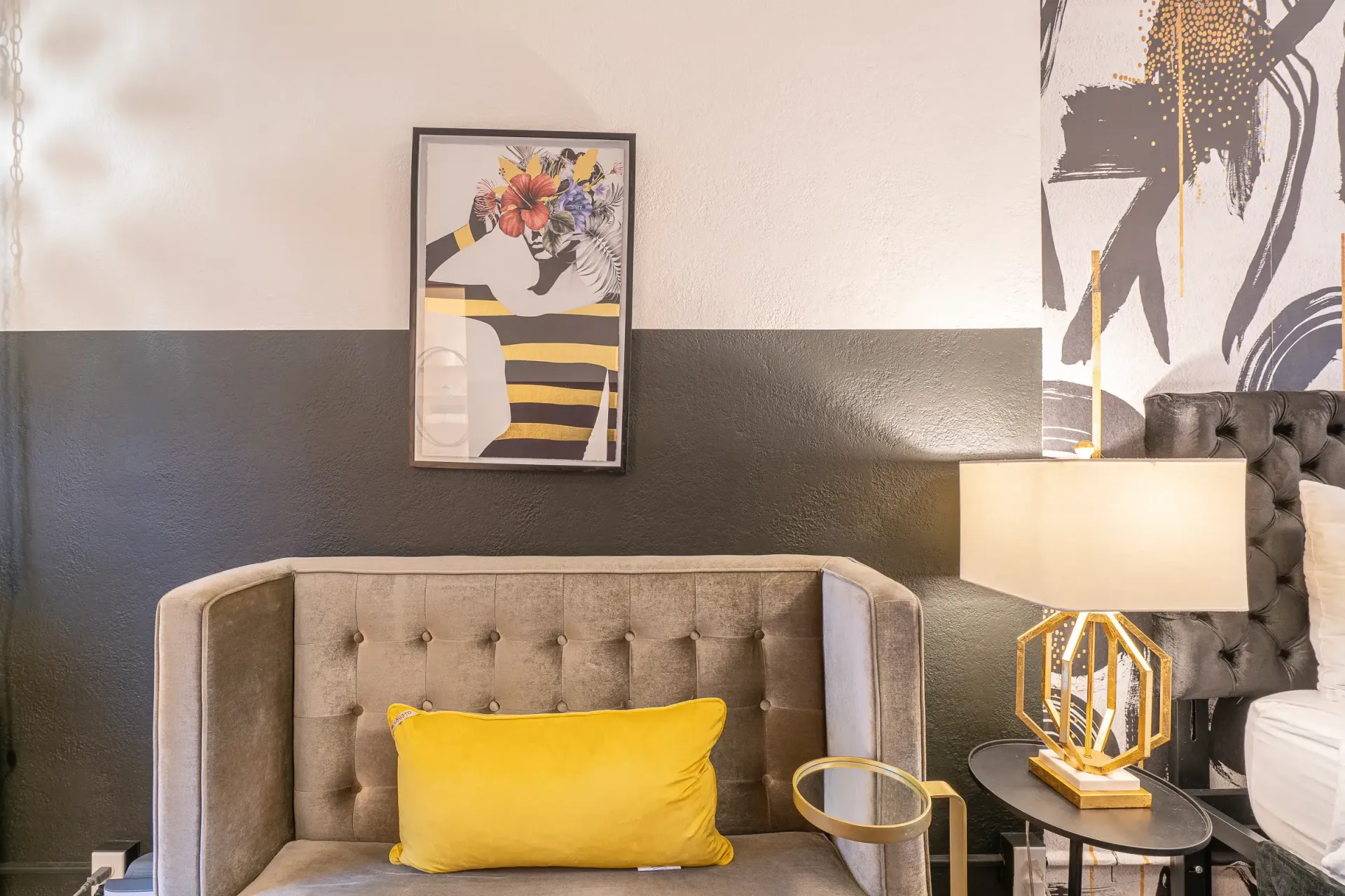A living room with a couch , chair , lamps and a picture on the wall.