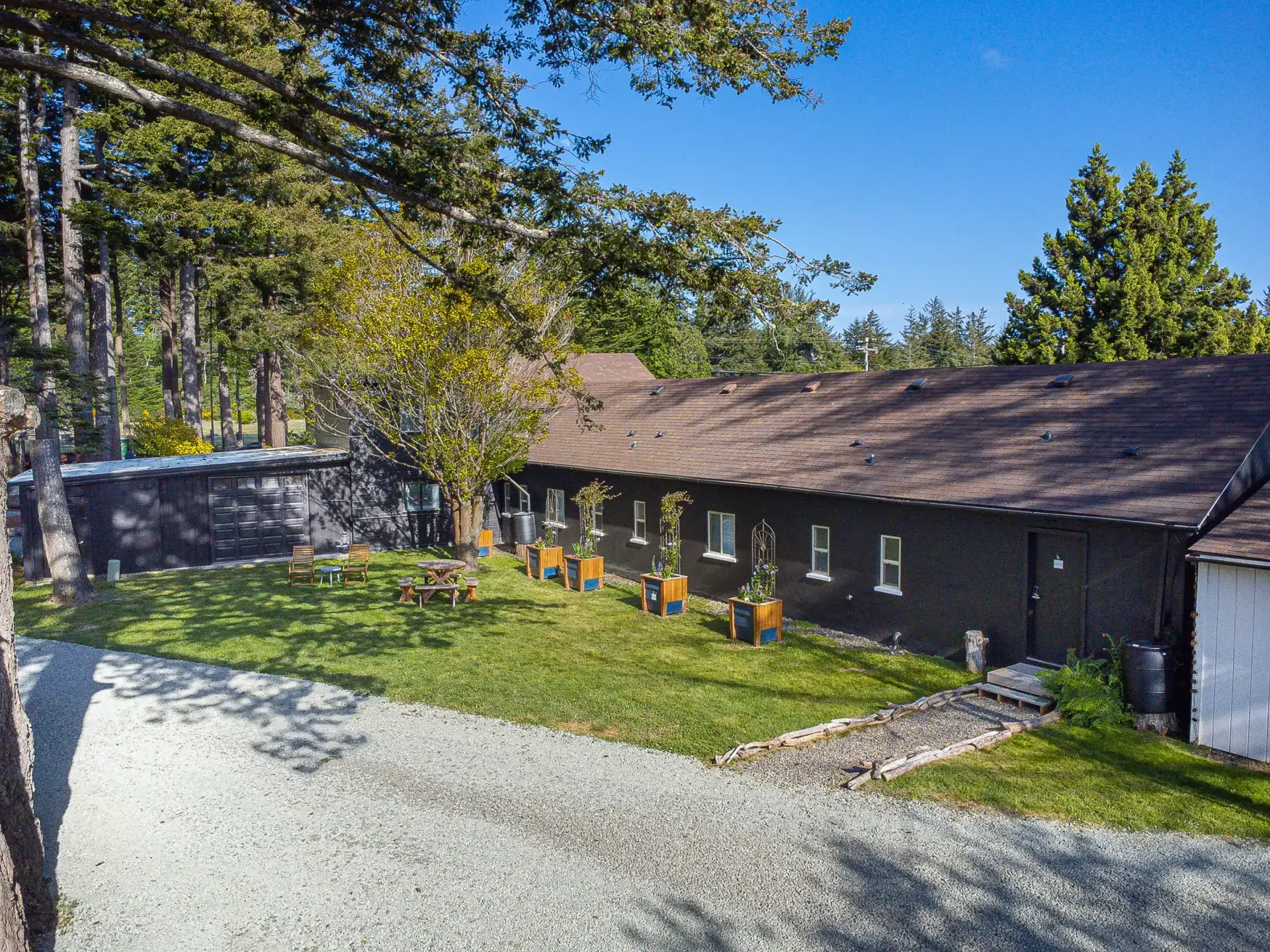 A large house with a lot of windows is surrounded by trees and grass.