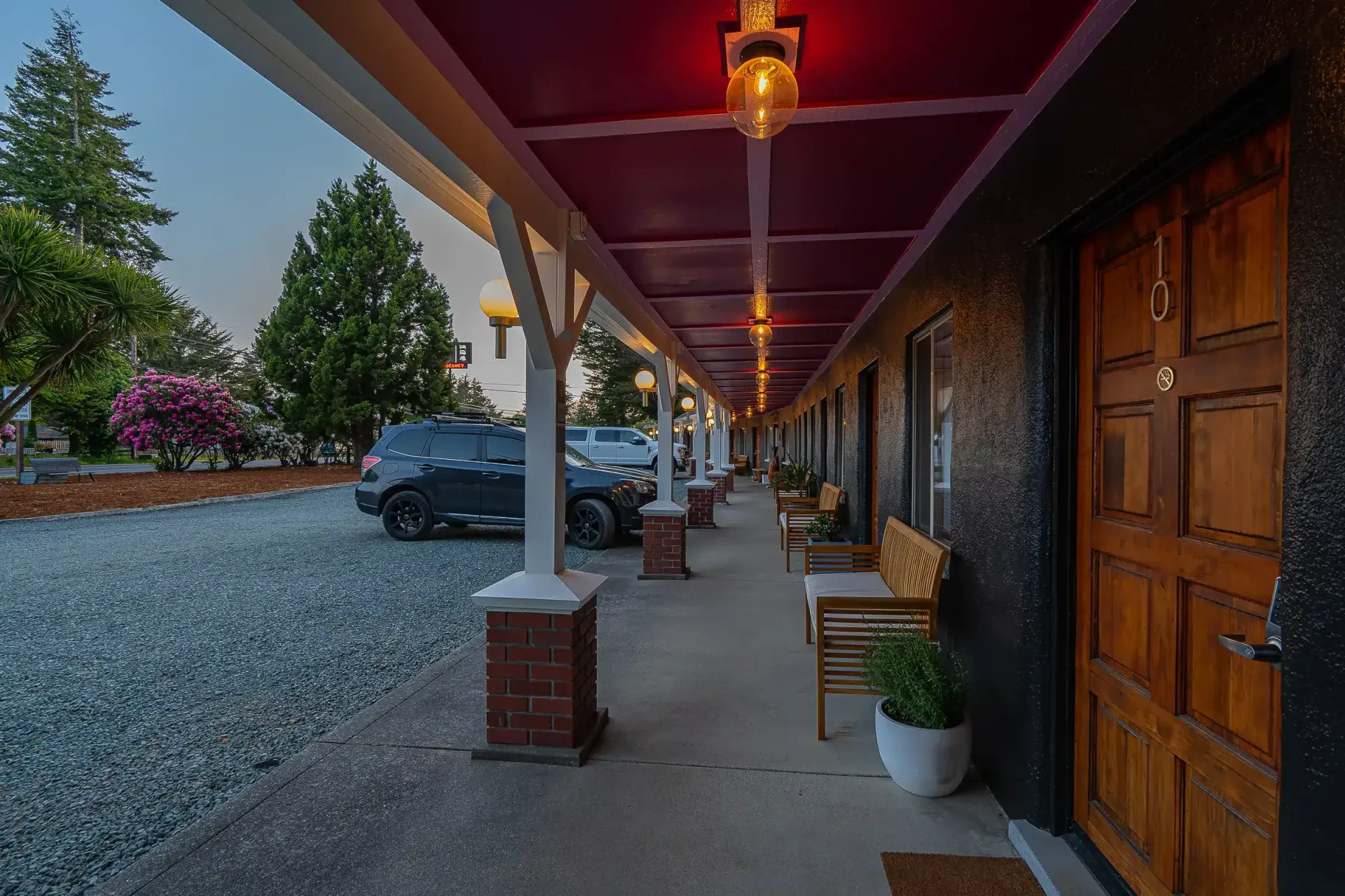 A motel with a covered walkway leading to the rooms.