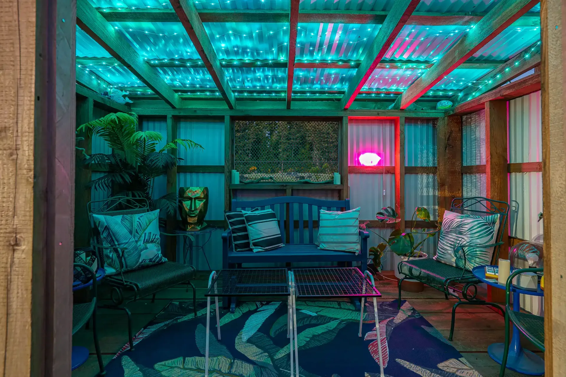A room with a couch , table , chairs , and a ceiling with lights.