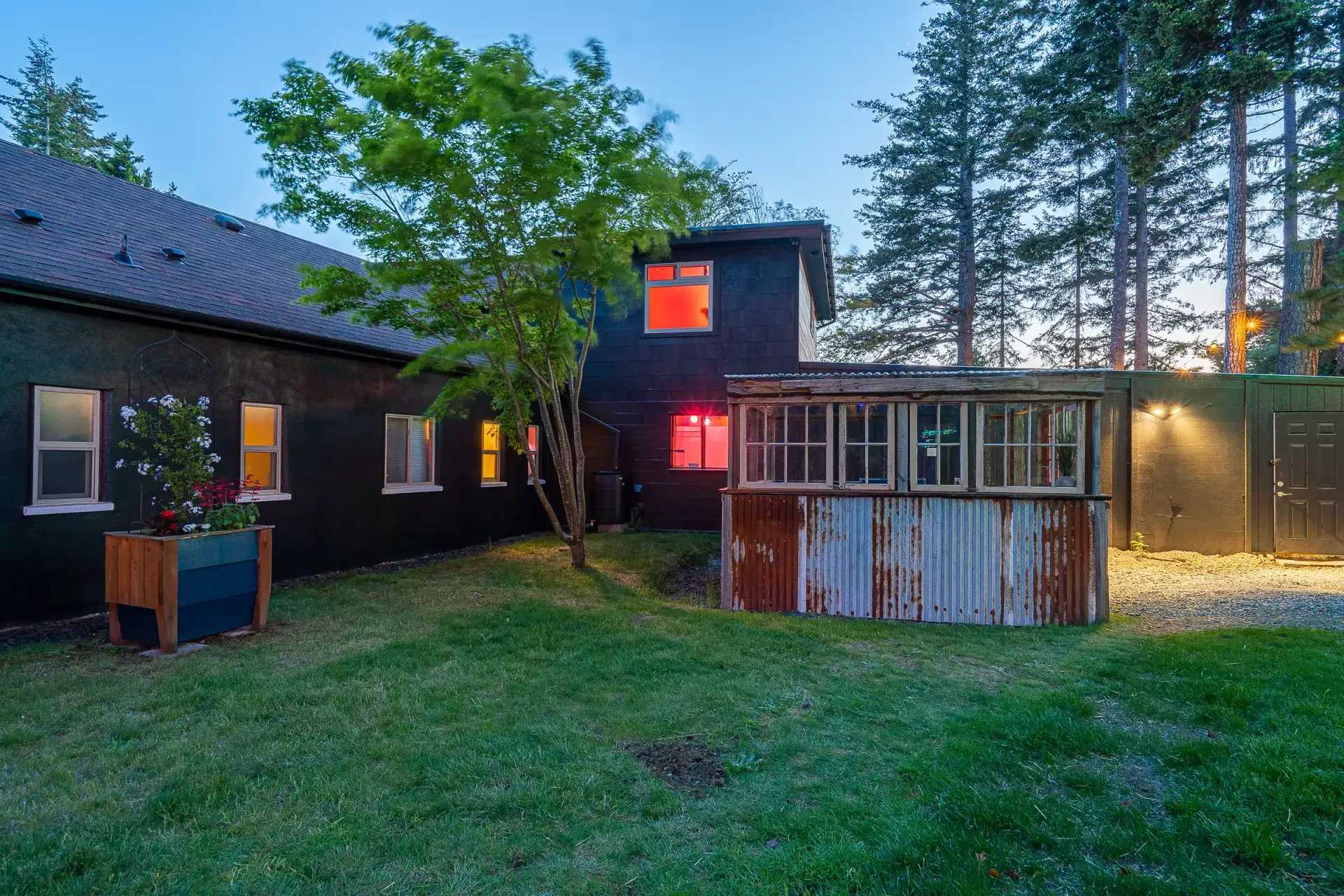 The backyard of a house with a shed in the middle of it.