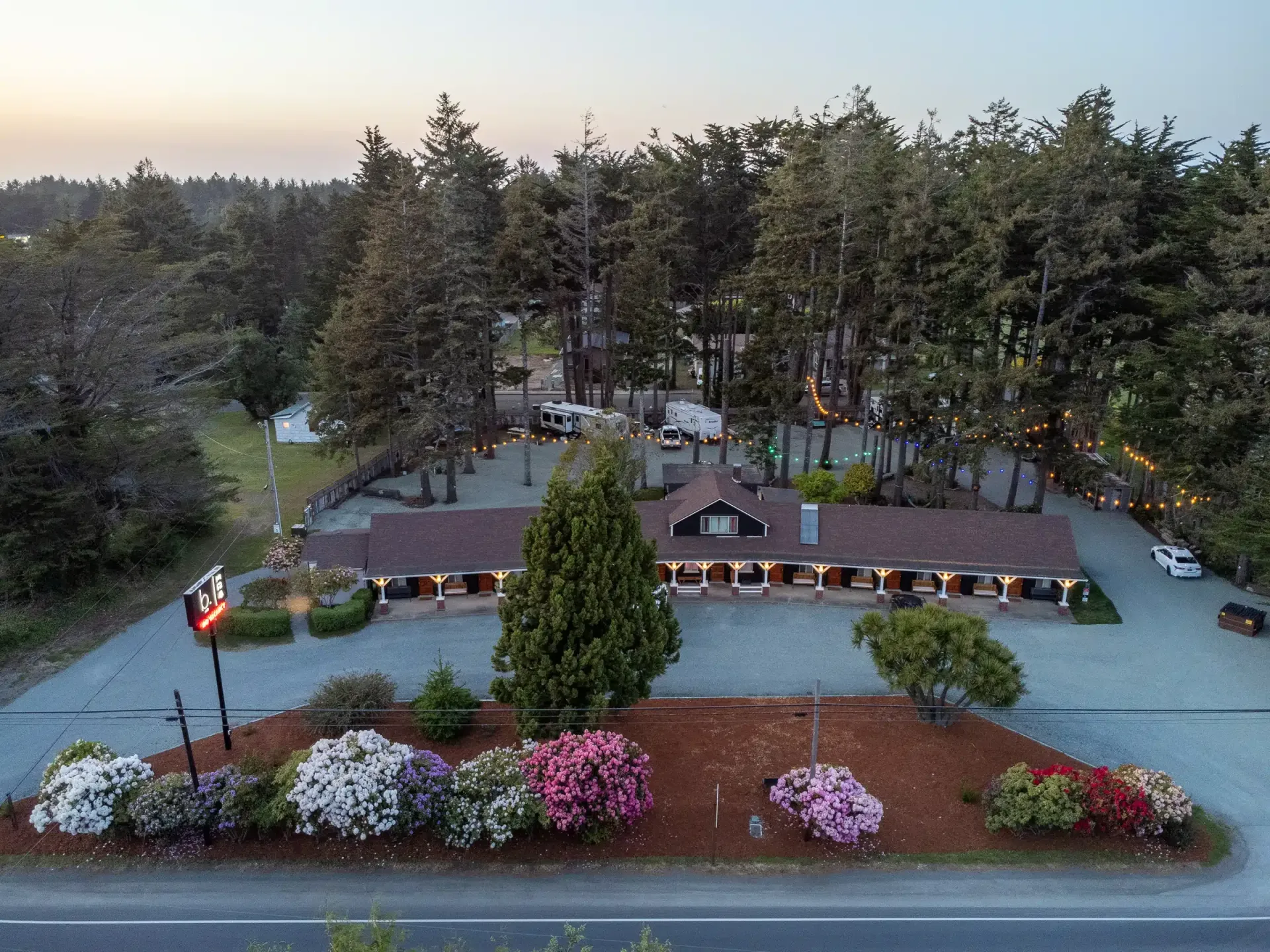 An aerial view of a house surrounded by trees and flowers