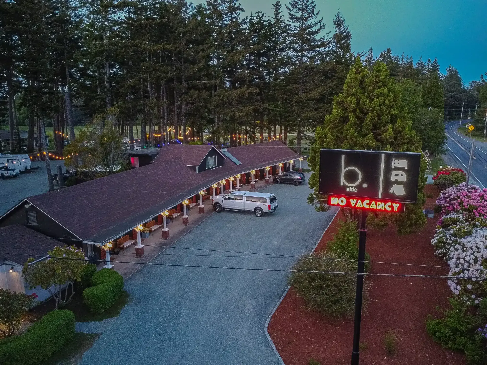 An aerial view of a motel with cars parked in front of it.