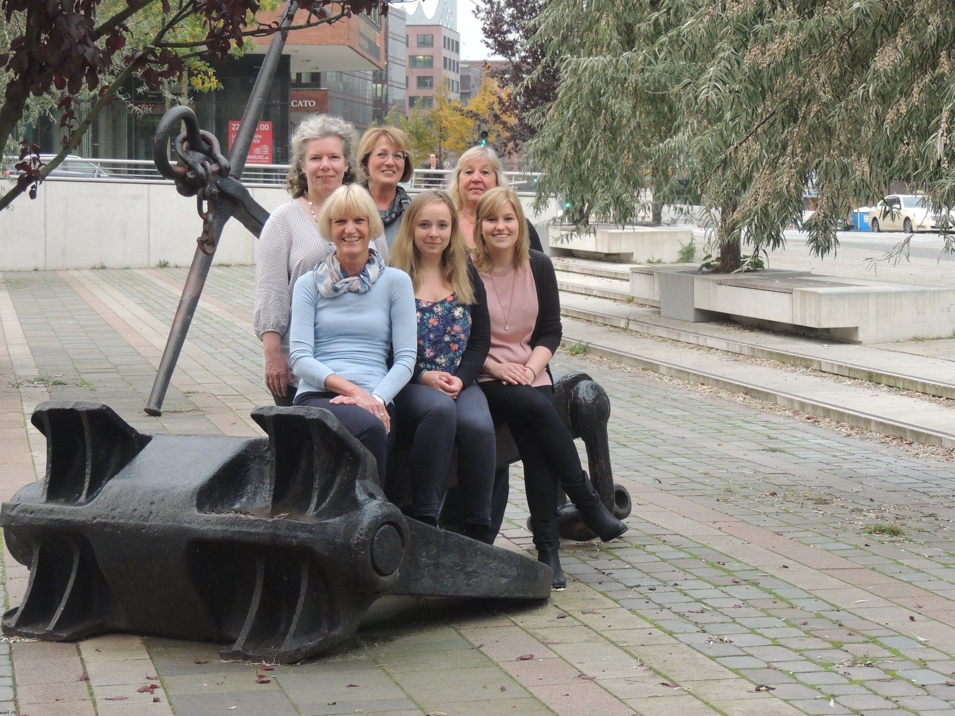 Eine Gruppe von Frauen posiert für ein Foto vor einem Anker